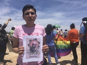 FILE - In this Wednesday, June 6, 2018 file photo, Gabriela Hernandez, executive director of the nonprofit New Mexico Dream Team, holds up an image in Albuquerque, N.M, of a Honduran transgender woman who died while in U.S. custody last month. Several migrants told New Mexico lawmakers Monday, July 16, 2018, that they were denied medication and adequate treatment while detained inside two different federal immigration facilities in the state. Joselin Mendez, of Nicaragua, blamed the death of Roxsana Hernandez, a Honduran transgender woman who died in the custody of the U.S. Immigration and Customs Enforcement, on the lack of sufficient medical treatment.