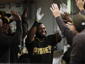 San Diego Padres' Manuel Margot is greeted in the dugout by teammates after hitting a home run during the second inning of a baseball game against the Arizona Diamondbacks, Friday, July 27, 2018, in San Diego.