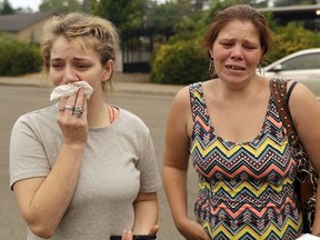 CORRECTS SPELLING TO SHERRY, NOT SHERRI-Sherry Bledsoe, left, cries next to her sister, Carla, outside of the sheriff's office after hearing news that Sherry's children, James and Emily, and grandmother, Melody Bledsoe, were killed in a wildfire Saturday, July 28, 2018, in Redding, Calif.