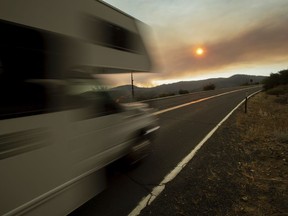 A recreational vehicle drives out of Yosemite Valley in Yosemite National Park, Calif., on Tuesday, July 24, 2018, as smoke from the Ferguson Fire fills the sky. Parts of the park, including Yosemite Valley, will close Wednesday as firefighters work to stop the blaze.