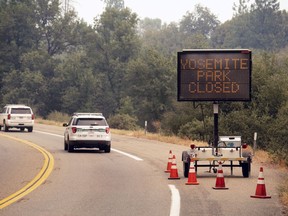 A sign on Highway 41 announces the closure of Yosemite National Park near Oakhurst, Calif., on Wednesday, July 25, 2018. Parts of the park closed Wednesday as firefighters work to contain the Ferguson fire burning nearby.