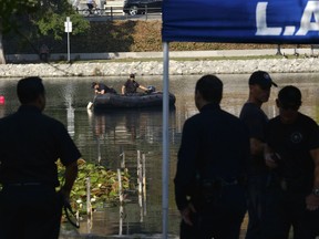 Los Angeles Police Department dive team members use sonar to search the bottom of Echo Park Lake near downtown Los Angeles on Thursday, July 26, 2018. Emergency crews are searching for up to three people who may have fallen out of pedal boats in the middle of the night on the lake in a Los Angeles park.