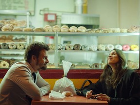 Alex and Valerie enjoying donuts as their father's ashes rest between them.