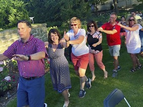 In this Saturday, July 7, 2018, photo provided by the Leah for Senate campaign, Wisconsin state Sen. Leah Vukmir, a candidate for the U.S. Senate, gives a thumbs up while taking part in a conga line with Gov. Scott Walker, left, during a party at the executive residence in Madison, Wis. (Leah for Senate campaign via AP)