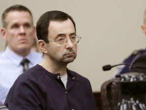FILE - In this Jan. 24, 2018, file photo, Larry Nassar sits during his sentencing hearing in Lansing, Mich. Michigan State University on Wednesday, July 25, 2018, halted payments from a $10 million fund it set up for counseling services for victims of now-imprisoned former sports doctor amid concerns about possible fraudulent claims.