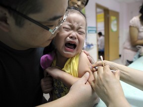 In this Sept. 11, 2010 file photo, a child cries while receiving a shot of measles vaccine at a health station in Hefei in central China's Anhui province.