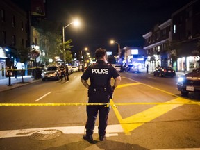 Police secure a perimeter around a scene of the mass shooting on Toronto's Danforth Avenue on July 22, 2018.