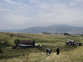FILE--In this Aug. 11, 2017 file photo, visitors approach a former ranch house and barn during a guided hike on the Rocky Flats National Wildlife Refuge near Denver, land that used to be a buffer zone around a nuclear weapons plant. Environmentalists and community activists are trying to stop the refuge from opening to the public this summer, claiming the U.S. Fish and Wildlife Service did not adequately study the safety of the site.
