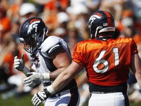 Denver Broncos defensive end Derek Wolfe, left, reacts after being injured while facing off against center Matt Paradis at the team's NFL football training camp Tuesday, July 31, 2018, in Englewood, Colo.