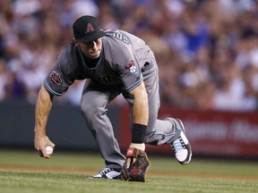 Arizona Diamondbacks first baseman Paul Goldschmidt tries to field a weak ground ball hit by Colorado Rockies' Ian Desmond but commits an error on the play to allow a runner to score from third during the fifth inning of a baseball game Tuesday, July 10, 2018, in Denver.