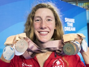 Canada's Taylor Ruck holds up her eight swimming medals at the Commonwealth Games in Australia on April 10.