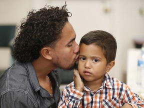 Roger Ardino 24, gives his son Roger Ardino Jr., 4, a kiss on the cheek shortly after speaking to reporters at a news conference at the Annunciation House in El Paso, Texas, Wednesday, July 11, 2018.