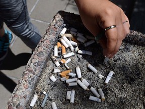 The Supreme Court of Canada says British Columbia does not have to give a tobacco company access to detailed provincial health databases to ensure the fairness of a multibillion-dollar damages trial. A smoker puts out a cigarette in a public ash tray in Ottawa on Tuesday, May 31, 2016.