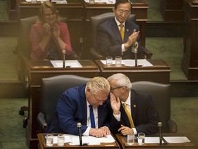 Ontario Premier Doug Ford's decision to cancel rebates for electric vehicles in the province is expected to have a knock-on effect on sales. Premier Ford leans in to listen to Finance Minister Victor Fedeli during the first Session of the 42nd Parliament of Ontario at Queen's Park in Toronto on Thursday, July 12, 2018.