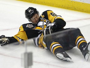 Pittsburgh Penguins' Sidney Crosby (87) lies on the ice after taking a hit from Washington Capitals' Matt Niskanen during the first period of Game 3 in an NHL Stanley Cup Eastern Conference semifinal hockey game against the Washington Capitals in Pittsburgh, Monday, May 1, 2017. Roughly half of Canadians know little to nothing about the perils of sports-related concussive injuries, nor where to turn to find information on how to avoid falling victim to them, suggests a newly released federal survey to gauge the country's understanding and awareness of concussions.