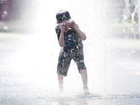 University of Waterloo climate scientist Blair Feltmate says the scorching heat wave that set records in Ontario and Quebec over the Canada Day long weekend can't be directly attributed to climate change. Seven-year-old Samuel Bedard from Quebec City runs through a water fountain as he beats the heat in Montreal, Monday, July 2, 2018.