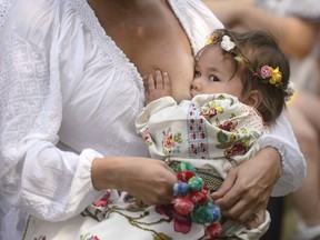 A woman breastfeeds her eighteen-month-old daughter Anastasia at an event promoting the freedom of mothers to breastfeed in public, during World Breastfeeding Week at the Village Museum in Bucharest, Romania, on August 6, 2016. Canadian breastfeeding advocates say they're stunned by an especially aggressive U.S. attempt to water down breastfeeding protections at a spring United Nations meeting. Elisabeth Sterken of the Infant Feeding Action Coalition in Canada says she was among the official observers in Geneva when a U.S. delegation took issue with various proposals that included marketing restrictions on breast milk substitutes.