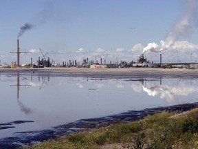 New government-funded research suggests that current levels of oilsands emissions will eventually acidify an area of northern Alberta and Saskatchewan the size of Germany. A tailings pond reflects the Syncrude oilsands mine facility near Fort McMurray, Alta., Wednesday, July 9, 2008.