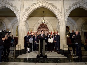 The federal government says it will try to bolster Canadian democratic institutions in the digital age due to growing public mistrust and concern about campaigns of false information and "fake news." Prime Minister Justin Trudeau speaks with media during an availability in the foyer with his caucus on Parliament Hill, in Ottawa on Tuesday, January 30, 2018.