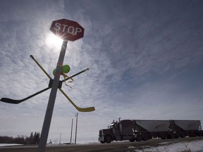 A pair of hockey sticks are seen attached to a stop sign along highway 5 south of Humboldt, Sask., Friday, April 13, 2018.