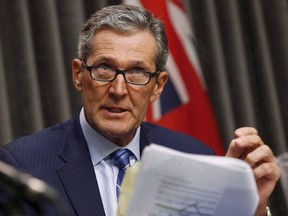 Manitoba Premier Brian Pallister reads during an announcement at the Manitoba Legislature in Winnipeg, Tuesday, November 7, 2017.