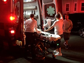 An Aetna Ambulance paramedic cares for an infant injured in a porch collapse in Hartford, Conn., on Saturday evening, July 7, 2018.