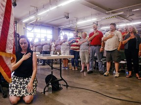 Selectwoman Melissa Schlag kneels for the Pledge of Allegiance during a Haddam, Conn., board of selectmen meeting on Monday, July 30, 2018 at the Haddam firehouse. Protestors and supporters gathered Monday night around a Haddam Town Meeting to address the recent controversy generated by Schlag's protest of the Pledge of Allegiance.