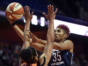FILe - In this July 17, 2018, file photo, Atlanta Dream forward Angel McCoughtry shoots over Connecticut Sun forward Alyssa Thomas during the first half of a WNBA basketball game, in Uncasville, Conn. McCoughtry says she is in a better place. And with her back in the Atlanta lineup after taking a year off from the WNBA, so are the Dream.