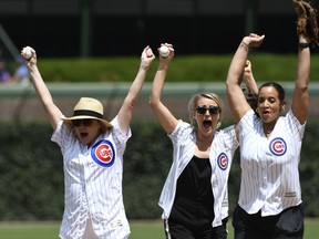 Orange is the New Black actresses, Kate Mulgrew, left, Taylor Schilling, center, and Dascha Polanco, right, react after throwing out a ceremonial first pitch before a baseball game between the Chicago Cubs and the Arizona Diamondbacks, Thursday, July 26, 2018, in Chicago.