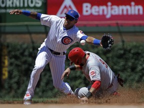 Cincinnati Reds' Jose Peraza, right, steals second base as Chicago Cubs shortstop Addison Russell tries to catch the ball during the first inning of a baseball game Friday, July 6, 2018, in Chicago.