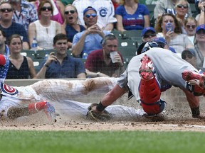 Chicago Cubs' Javier Baez steals home past Detroit Tigers catcher James McCann during the fourth inning of a baseball game on Wednesday, July 4, 2018, in Chicago.