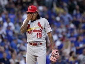 St. Louis Cardinals starting pitcher Carlos Martinez wipes his face after giving up a run during the third inning of a baseball game against the Chicago Cubs, Thursday, July 19, 2018, in Chicago.