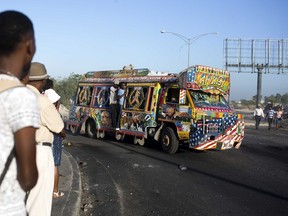 A painted bus filled with passengers makes its way along the street on the second day of a nationwide, general strike in Port-au-Prince, Haiti, early Tuesday, July 10, 2018. While some opposition leaders have called off the strike for Tuesday, most businesses remained closed following days of violent protests against a 50 percent fuel hike, part of a plan endorsed by the IMF to modernize the economy, and calls for the resignation of President Jovenel Moise, whose government suspended the hike.