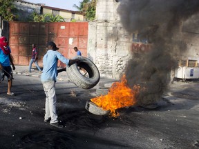 People set up a barricade in the middle of the street during a protest over the cost of fuel in Port-au-Prince, Haiti, Saturday, July 7, 2018. Major protests erupted Friday in Haiti as the government announced a sharp increase in gasoline prices.