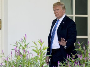 President Donald Trump waves to members of the media as he walks towards the West Wing of the White House in Washington, Wednesday, July 18, 2018, after returning from Andrews Air Force Base, and paying respects to the family of fallen U.S. Secret Service special agent Nole Edward Remagen who suffered a stroke while on duty in Scotland.