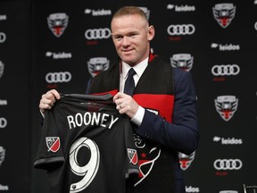 English soccer star Wayne Rooney, the all-time leading scorer for England's national team and Manchester United in the Premier League, poses with his new jersey during a news conference announcing his signing with MLS team D.C. United, Monday, July 2, 2018, at the Newseum in Washington.
