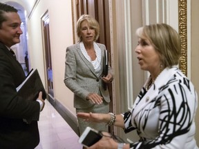 Education Secretary Betsy DeVos, center, has a final word with Hispanic Caucus Chair Rep. Michelle Lujan Grisham, D-N.M., right, following a meeting on Capitol Hill in Washington, Thursday, July 26, 2018.