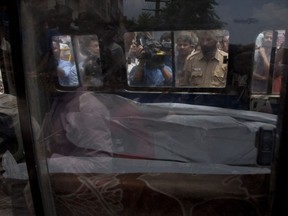 An ambulance carries one of the 11 bodies found in Burari village, north Delhi, India, on Sunday, July 1, 2018.