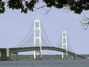 FILE - In this July 19, 2002 file photo, the Mackinac Bridge that spans the Straits of Mackinac is shown from Mackinaw City, Mich. A draft of a report released Thursday, July 19, 2018, commissioned by the state of Michigan outlining a worst-case scenario oil spill from a pipeline in the Straits of Mackinac calculates clean-up, restoration and liability costs at almost $2 billion.
