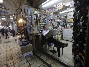 In this Wednesday, July 11, 2018 photo, a shopkeeper waits for customers in the Muslim Quarter of the Old City in Jerusalem. A half-a-billion-dollar Israeli plan to develop Palestinian areas of east Jerusalem and hoist tens of thousands of residents out of poverty is getting a cool reception from the very people who are supposed to benefit. Israel says it hopes the program will improve living conditions in impoverished Palestinian neighborhoods and give residents access to Israel's high-tech economy. But Palestinians fear the plan is a way of cementing Israel's control over the city.