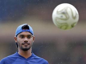 Sri Lanka's Sri Lanka's Dhananjaya de Silva looks at a soccer ball after their  practice session is disrupted due to rain ahead of the first test cricket match against South Africa in Galle, Sri Lanka, Wednesday, July 11, 2018. Sri Lanka will play a two match test series with touring South Africa starting from Thursday.