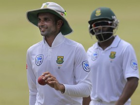 South Africa's Keshav Maharaj, left, leaves the field as he acknowledges the applause from the crowd after taking the ninth Sri Lankan wicket during the second day's play of their second test cricket match in Colombo, Sri Lanka, Saturday, July 21, 2018.