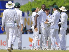 South Africa's Kagiso Rabada, center without cap, is congratulated by his teammates after dismissing Sri Lanka's Niroshan Dickwella during the third day's play of their first test cricket match in Galle, Sri Lanka, Saturday, July 14, 2018.