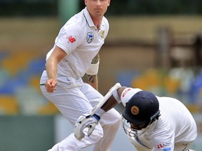 South Africa's Dale Steyn, left, watches Sri Lanka's Dimuth Karunaratne, right, dive to make it successfully to the crease during the first day's play of their second test cricket match in Colombo, Sri Lanka, Friday, July 20, 2018.