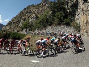 The pack climbs Montvernier road during the twelfth stage of the Tour de France cycling race over 175.5 kilometers (109 miles) with start in Bourg-Saint-Maurice Les Arcs and Alpe d'Huez, France, Thursday, July 19, 2018.