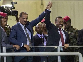 Eritrean President Isaias Afwerki, second left, and Ethiopia's Prime Minister Abiy Ahmed, center, hold hands as they wave at the crowds in Addis Ababa, Ethiopia, Sunday July 15, 2018. Official rivals just weeks ago, the leaders of Ethiopia and Eritrea have embraced warmly to the roar of a crowd of thousands at a concert celebrating the end of a long state of war. A visibly moved Eritrean President Isaias Afwerki, clasping his hands over his heart, addressed the crowd in Ethiopia's official language, Amharic, on his first visit to the country in 22 years.