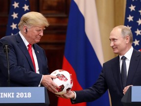 U.S. President Donald Trump, left, receives a soccer ball from Vladimir Putin, Russia's president, during a news conference in Helsinki, Finland, on Monday, July 16, 2018.