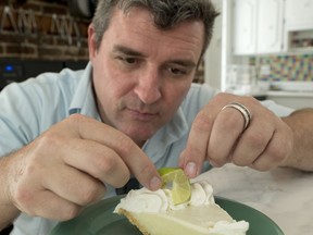 In this photo provided by the Florida Keys News Bureau, David Sloan, author of a Key lime pie cookbook, decorates a slice of Key lime pie Tuesday, July 31, 2018, in Key West, Fla. Sloan and other Florida Keys culinary experts are disputing dessert cookbook author Stella Parks' claim that the Keys' signature dessert was not invented in the island chain.