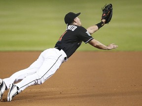 Miami Marlins first baseman J.T. Realmuto dives and misses the ball on a bunt pop-up by Washington Nationals' Trea Turner during the first inning of a baseball game Saturday, July 28, 2018, in Miami.