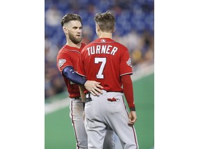 Washington Nationals' Bryce Harper, left, gestures at Trea Turner's back after Turner was hit by the ball at bat during the third inning of a baseball game against the, Sunday, July 29, 2018, in Miami.